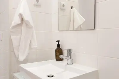 a white bathroom sink with a soap dispenser on it at VIVA Merchant's Way in Porto