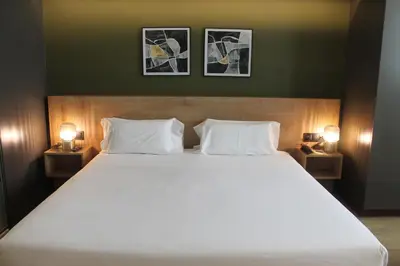 a bedroom with a large white bed with two lamps at Oca Ribeira do Porto AT in Porto
