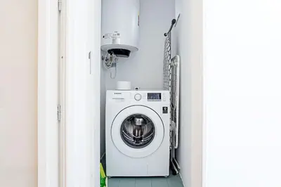 a washer and dryer sitting in a room at Wonderful Duplex W Private Patio & AC by LovelyStay in Porto