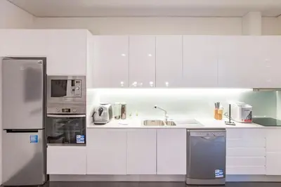 a kitchen with white cabinets and stainless steel appliances at GuestReady - Fantástico apt em Santa Catarina in Porto