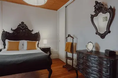 a bedroom with a bed and a dresser and a mirror at Alegria Four - Bedroom House in Porto