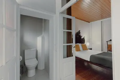 a white bedroom with a bed and a toilet at Alegria Four - Bedroom House in Porto