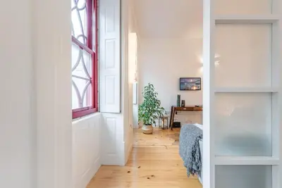 a hallway with a window and a table with a plant at GuestReady - Rustic urban retreat in Porto