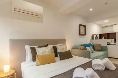 a bedroom with a large white bed and a couch at Underground Batalha Studios in Porto
