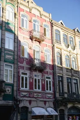 a tall brick building with balconies on a street at Bolhão Studio, Porto in Porto