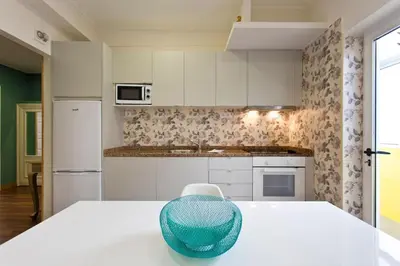 a white kitchen with a blue bowl on a table at APOSENTUS - Serenity 1D in Porto