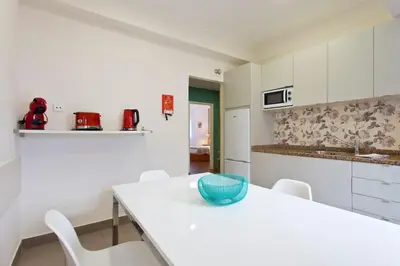 a white kitchen with a blue bowl on a table at APOSENTUS - Serenity 1D in Porto