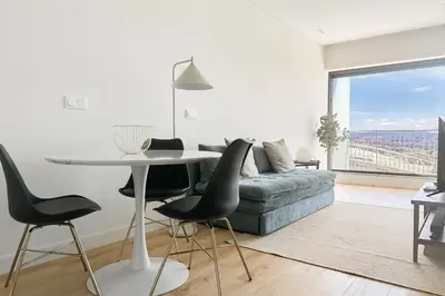 a living room with a couch and a table and chairs at Dragão Rooftop in Porto