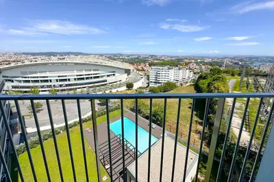 a balcony with a view of a building and a pool at Dragão Rooftop in Porto