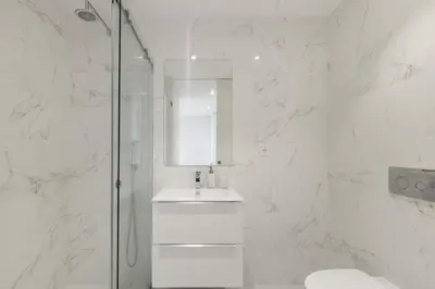 a white bathroom with a sink and a shower at Dragão Rooftop in Porto
