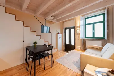 a living room with a staircase and a table at DOISPONTOZERO Oliveirinhas in Porto