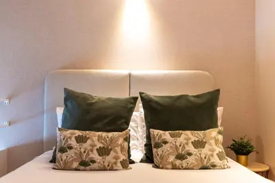 a bed with two pillows and a headboard at DOISPONTOZERO Oliveirinhas in Porto