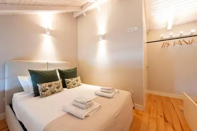 a bedroom with a bed with towels on it at DOISPONTOZERO Oliveirinhas in Porto