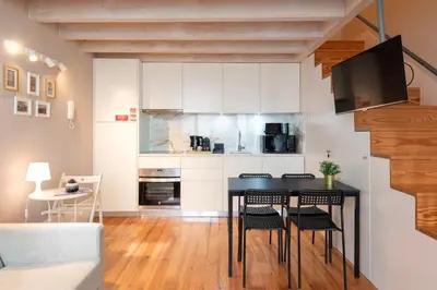 a kitchen with a black table and chairs in a room at DOISPONTOZERO Oliveirinhas in Porto