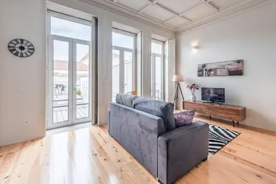 a living room with a gray couch and windows at GuestReady - Seaside getaway in Porto in Porto