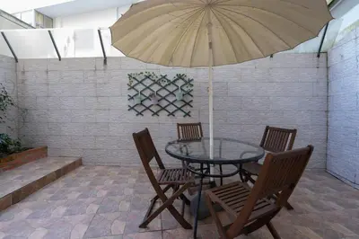 a table with chairs and an umbrella on a patio at APOSENTUS - Serenity Terrace in Porto