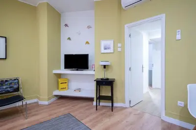 a living room with a flat screen tv and a hallway at APOSENTUS - Serenity Terrace in Porto