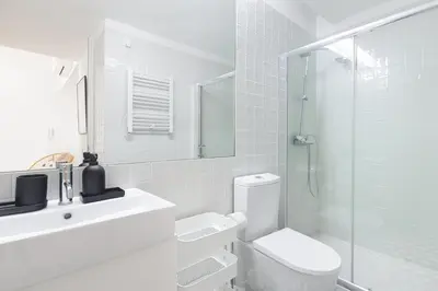 a white bathroom with a toilet and a shower at República Garden View in Porto