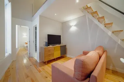 a living room with a couch and a tv at Downtown Amazing Duplex by Vacationy in Porto