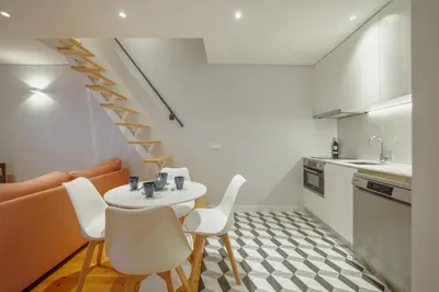 a kitchen with a table and chairs and a staircase at Downtown Amazing Duplex by Vacationy in Porto