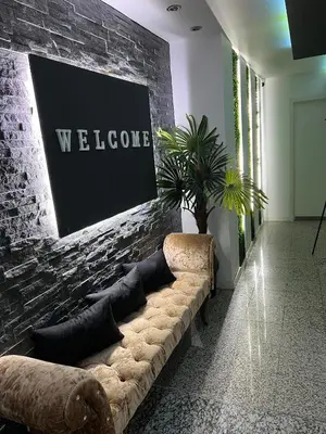 a couch against a brick wall with a welcome sign at Modern & Central 3 minutes from the River in Vila Nova de Gaia