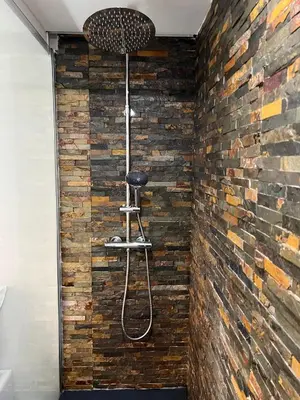 a shower in a room with a brick wall at Modern Room with Indoor Shower Near the River - Quarto Moderno com Duche interior Próximo da Ribeira in Vila Nova de Gaia