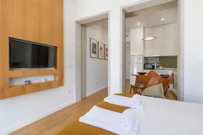 a living room with white walls and a flat screen tv at WALAA Home@Almada Terrace by LovelyStay in Porto