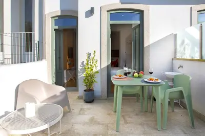 a patio with a table and chairs on a balcony at WALAA Home@Almada Terrace by LovelyStay in Porto