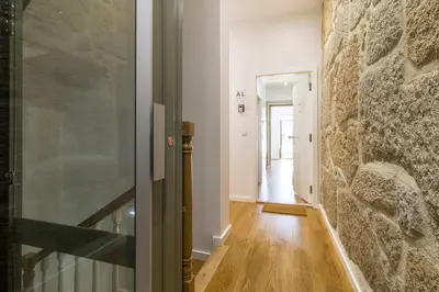 a hallway with a stone wall and a glass door at WALAA Home@Almada Terrace by LovelyStay in Porto