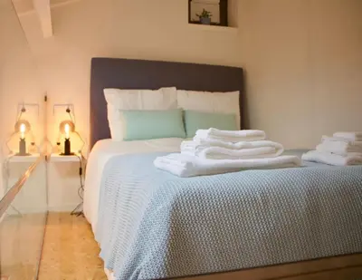 a bedroom with a bed with towels on it at Ilhas Douro Fontaínhas by PA Hotels in Porto