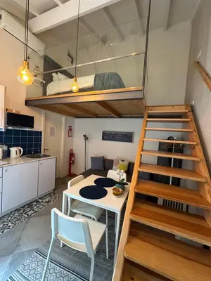 a room with a table and a loft bed at Ilhas Douro Fontaínhas by PA Hotels in Porto