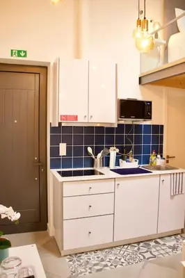 a kitchen with white cabinets and a sink at Ilhas Douro Fontaínhas by PA Hotels in Porto