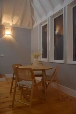 a table and chairs with a vase on top of it at The Nest in Porto
