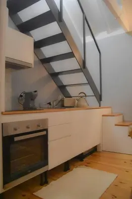 a kitchen with a stove and a staircase at The Nest in Porto
