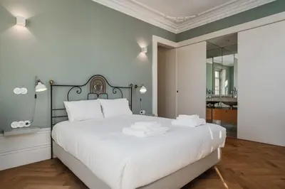 a bedroom with a white bed and a mirror at Victoria Luxury Apartment, Historic House Downtown in Porto