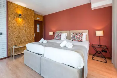 two beds in a room with red walls at GuestReady - Portfolio GuestHouse in Porto