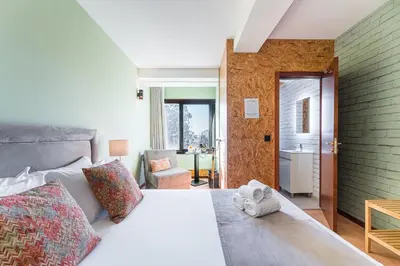 a bedroom with a bed and a chair in a room at GuestReady - Portfolio GuestHouse in Porto