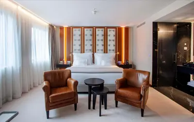 a hotel room with a bed and two chairs at Wine & Books Porto Hotel - Small Luxury Hotels Of The World in Porto