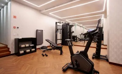 a gym with treadmills and exercise bikes in a room at Wine & Books Porto Hotel - Small Luxury Hotels Of The World in Porto
