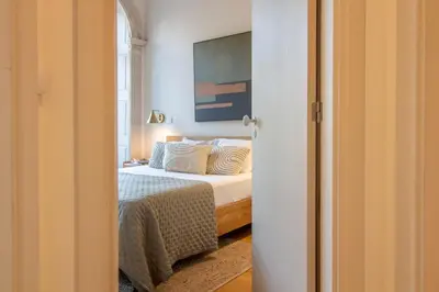 a bedroom with a bed and a painting on the wall at Casa Azul Santa Marinha in Vila Nova de Gaia