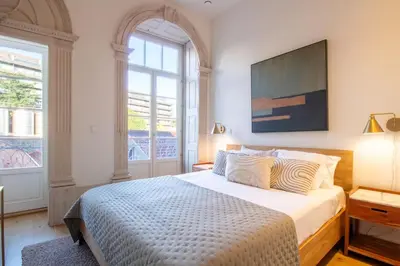 a bedroom with a large bed with a tv on the wall at Casa Azul Santa Marinha in Vila Nova de Gaia