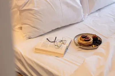 a plate of food and a book on a bed at Casa Azul Santa Marinha in Vila Nova de Gaia