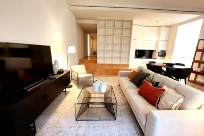 a living room with a white couch and a tv at Dream On - Aliados Delux 2 Bed in Porto