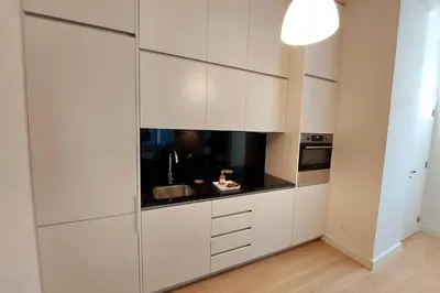 a white kitchen with white cabinets and a sink at Dream On - Aliados Delux 2 Bed in Porto