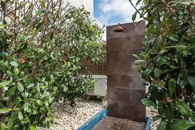 a garden with trees and a brick wall at Porto InLapa Studio VI Garden in Porto