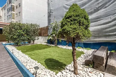 a small garden with a small tree and rocks at Porto InLapa Studio VI Garden in Porto