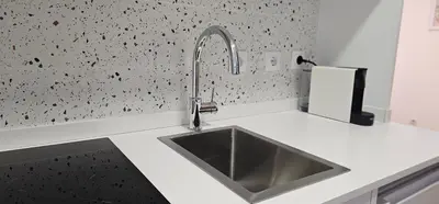 a kitchen with a sink in a white counter top at Terrace Douro in Vila Nova de Gaia
