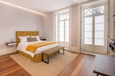 a bedroom with a bed and two windows at Porto Almada 180 Apartments in Porto