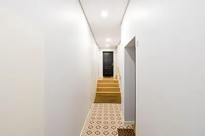 a hallway of a house with white walls and a black door at Bonfim Elegant Duplex w/ AC by LovelyStay in Porto