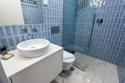 a blue tiled bathroom with a sink and a toilet at Trindade - Loft apartment in Porto